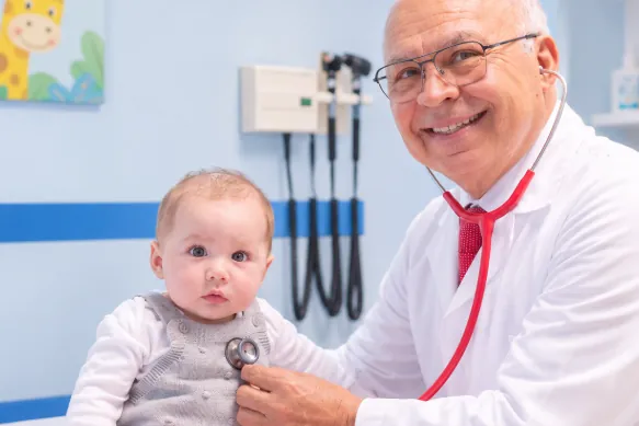 El Dr. Cipriano Aguilar ausculta a un bebé con tos en su consultorio de Mexicali